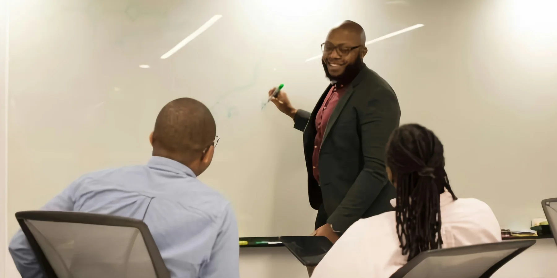 Facilitator sketching ideas on a whiteboard during a team workshop